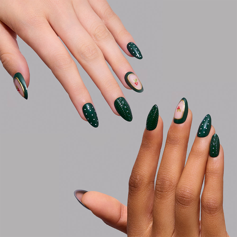 Table for Ten short almond nails by Glamnetic in forest green, featuring a mix of textures, white polka dots, and small cherry-themed accents in a stylish holiday manicure. - Product image