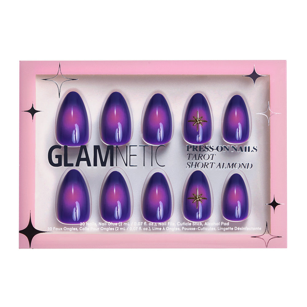 The glamnetic Tarot press-on nail set features short almond nails with a mystical purple-to-pink gradient. One nail is embellished with a gold star and gem. The nails come boxed in pink packaging with black and white text, accented by decorative stars. - Product image