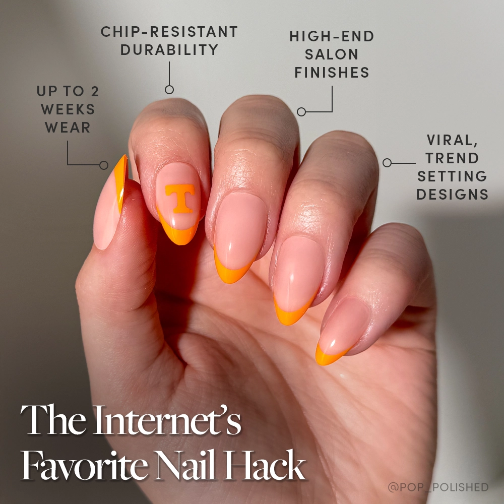 A hand with a glamnetic Tennessee Volunteers Press-On Nail Set shows orange French tips and a “T” accent nail. Enjoy chip-resistant durability, salon-quality finish, up to 2 weeks wear, and viral Rocky Top-inspired designs. - Product image