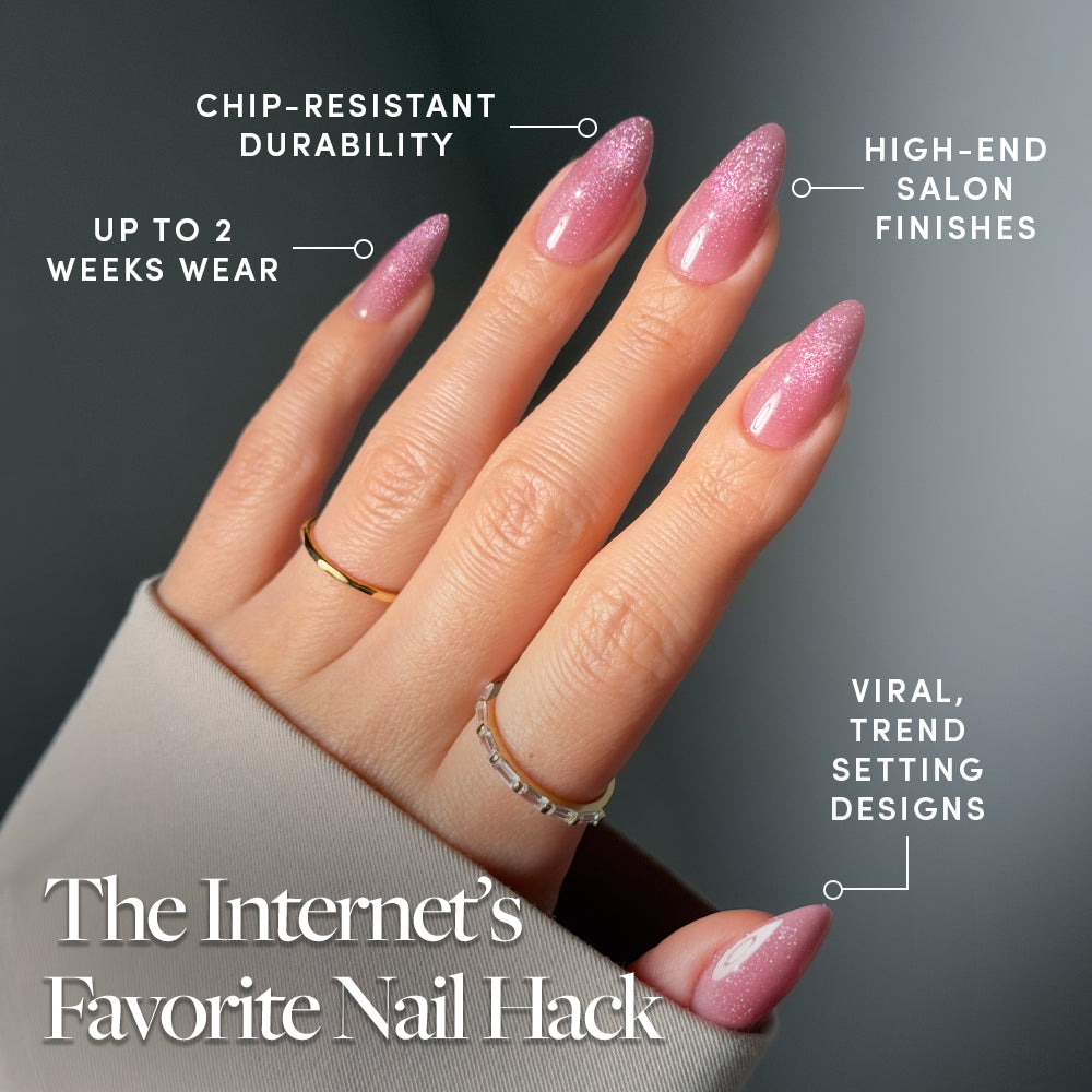 A hand with long, pink ombre almond press-ons from glamnetic's THE BEAUTY BLUEPRINT is shown with gold rings. The smooth, glossy nails offer chip-resistant durability, trend-setting designs, salon-quality finish, and up to 2 weeks of wear. - Product image