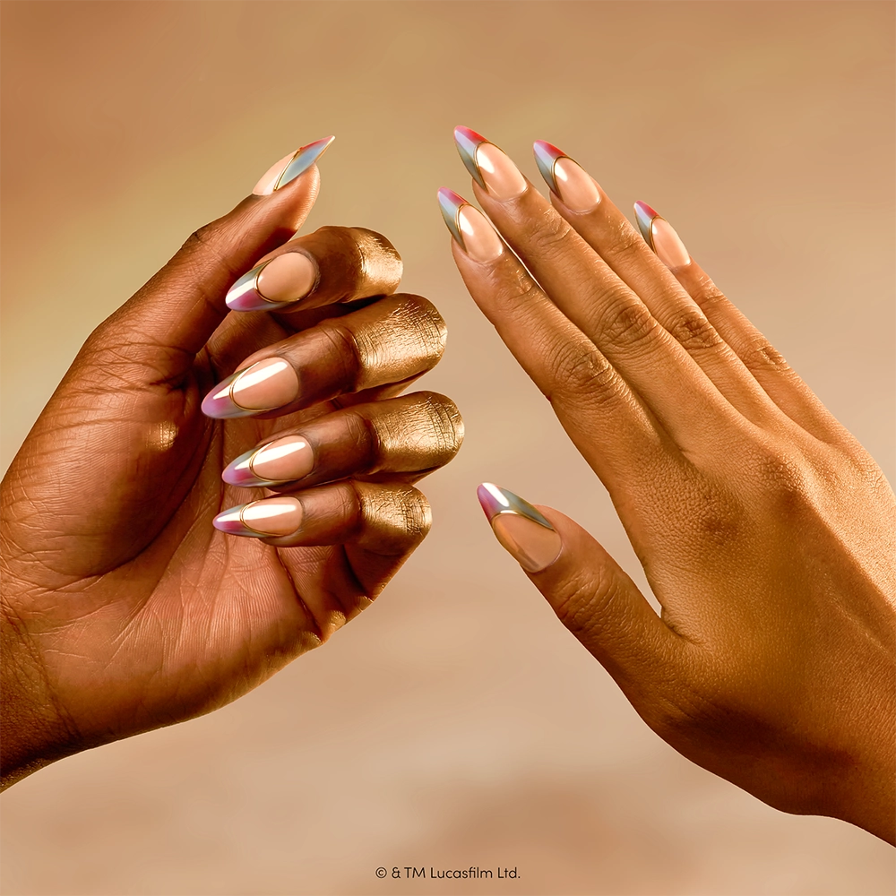 The Jedi Order - Two hands display almond-shaped nails with a metallic, multicolored chrome French tip design against a warm, soft-focus beige background, showcasing the elegant “The Jedi Order” press-on nails set by glamnetic.