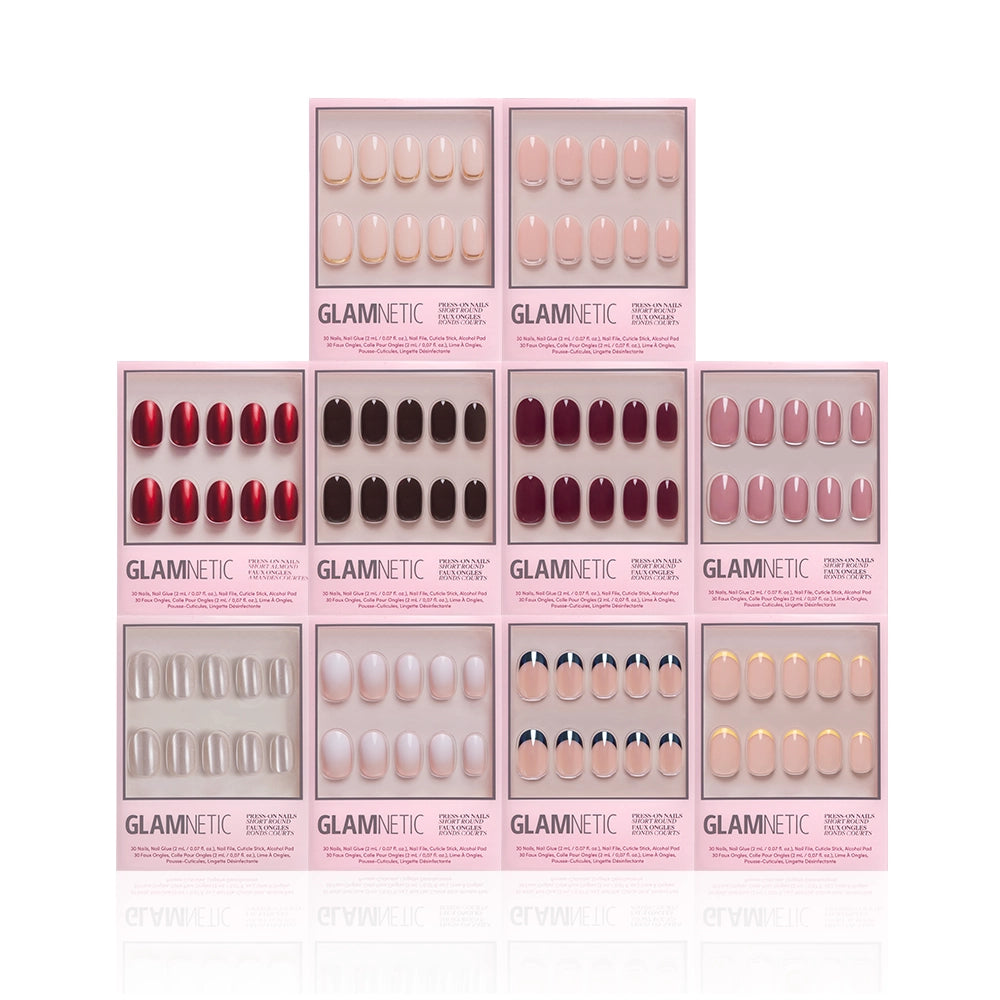 Ten boxes of glamnetic’s The Round Vault are stacked in a pyramid, showcasing short round press-on nails in red, black, nude, pink, French tips, and ombre—a stunning limited-edition set for every look. - Product image