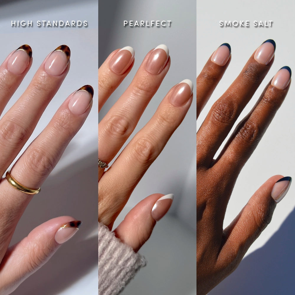Three hands showcase glamnetic’s The Short Oval Frenchies: left hand with a gold ring and tortoiseshell tips (High Standards), middle with pearly white tips (Pearlfrect), and right with dark blue tips (Smoke Salt).