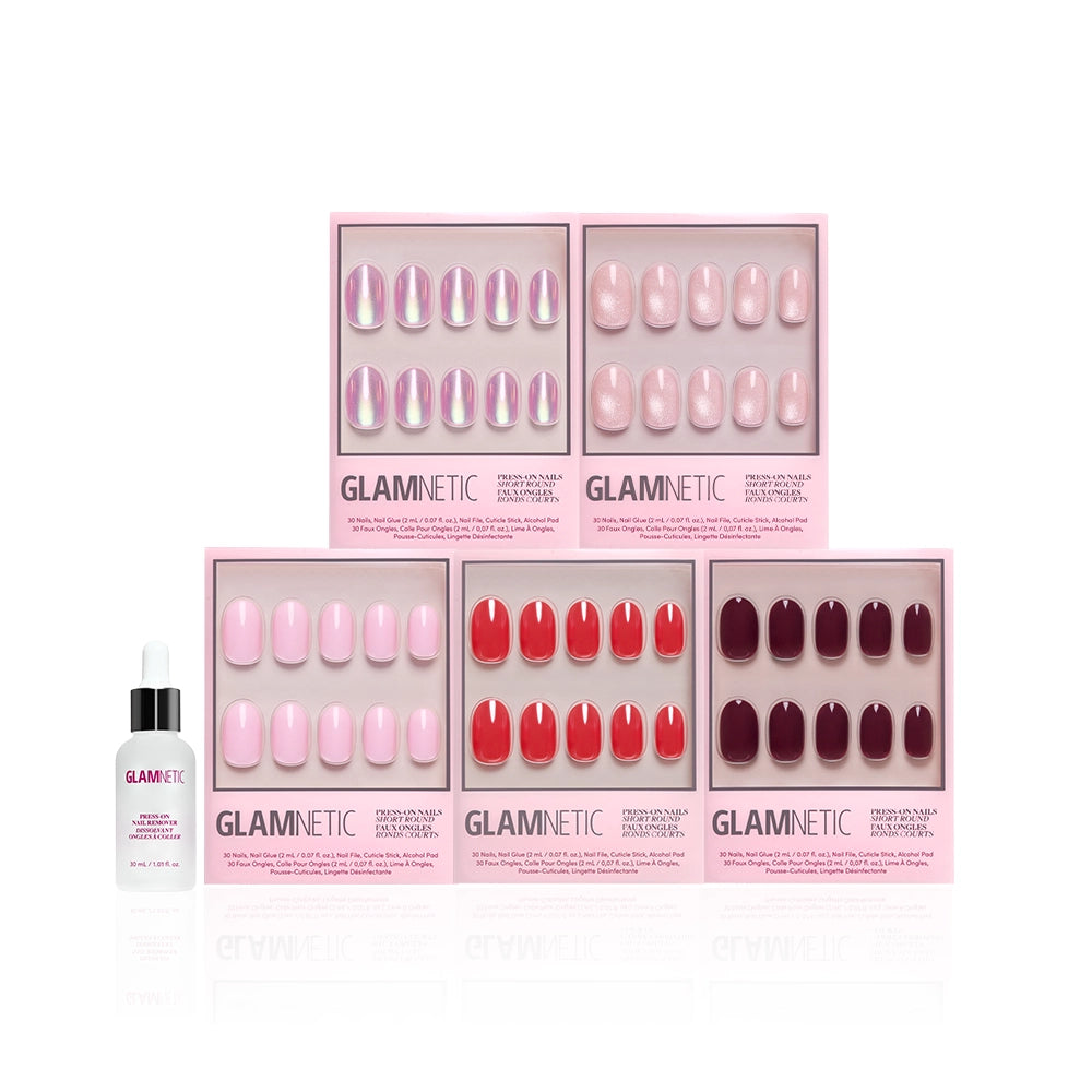 Six boxes of glamnetic’s The Short Round Edit press-on nails in glossy pink, red, and burgundy are arranged in two rows with a bottle of glamnetic nail glue in front, all displayed on a white background. - Product image
