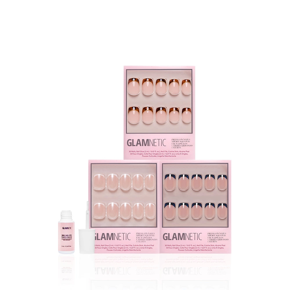 Three boxes of glamnetic The Short Squoval Frenchies press-on nails are stacked on a white surface. An open bottle of nail glue sits to the left, showcasing these stylish short squoval nails against a clean, white background. - Product image