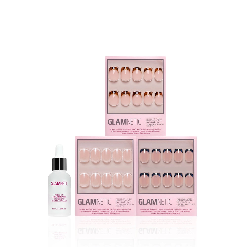 Three boxes of glamnetic's The Short Squoval Frenchies press-on nails in pink packaging are arranged pyramid-style with a bottle of cuticle oil in front, all displayed against a white background. - Product image