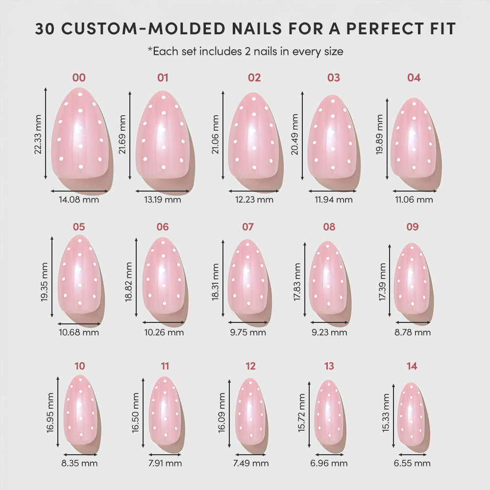 Chart displaying 15 sizes of glamnetic’s "Barely Spotted" custom-molded pink polka dot nails, labeled 00–14, each with length and width in millimeters, showing a variety of shapes and sizes arranged in rows. - Product image