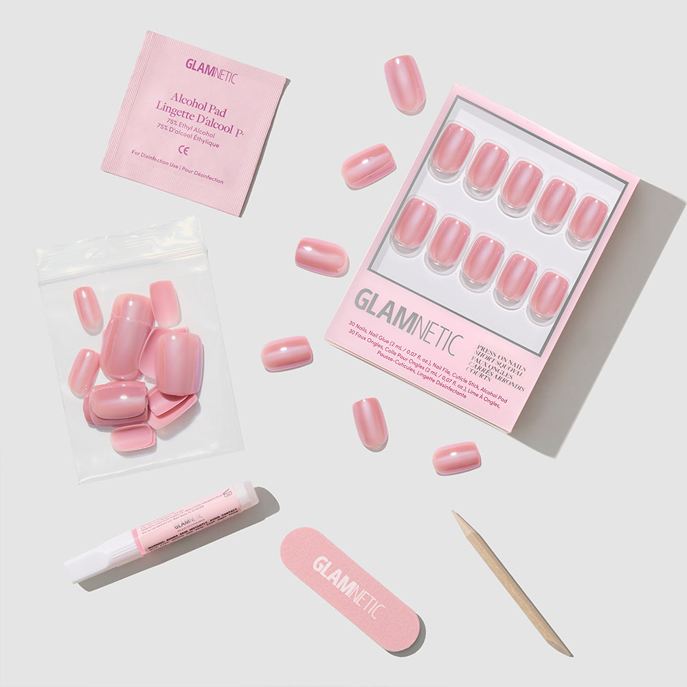 Glamnetic's Mauve On Up set features vegan, extra short squoval mauve pink press-on nails with glue, nail file, wooden cuticle stick, and alcohol pad, all arranged neatly on a white background. - Product image