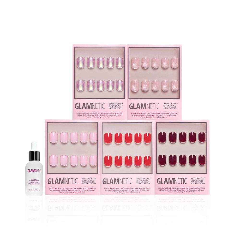 Five boxes of glamnetic's The Super Short Edit press-on nails in pink and red shades are arranged in two rows on a white background, with a glamnetic nail glue dropper bottle to the left of the bottom row. - Product image