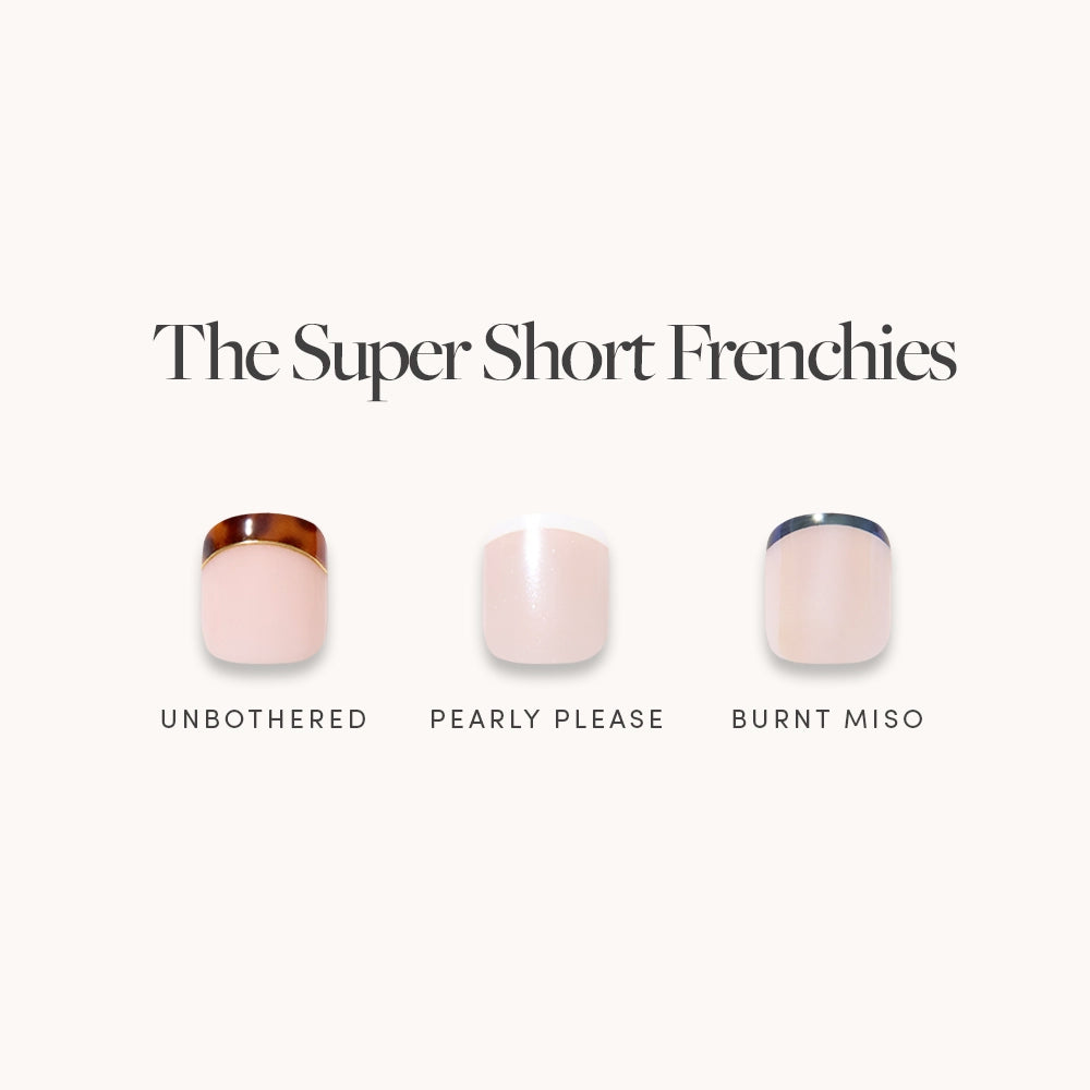 The Super Short Frenchies by glamnetic features three super short press-on nails: Unbothered (brown tip), Pearly Please (pearly white tip), and Burnt Miso (dark brown tip) on light pink bases—perfect for a quick, stylish French mani.