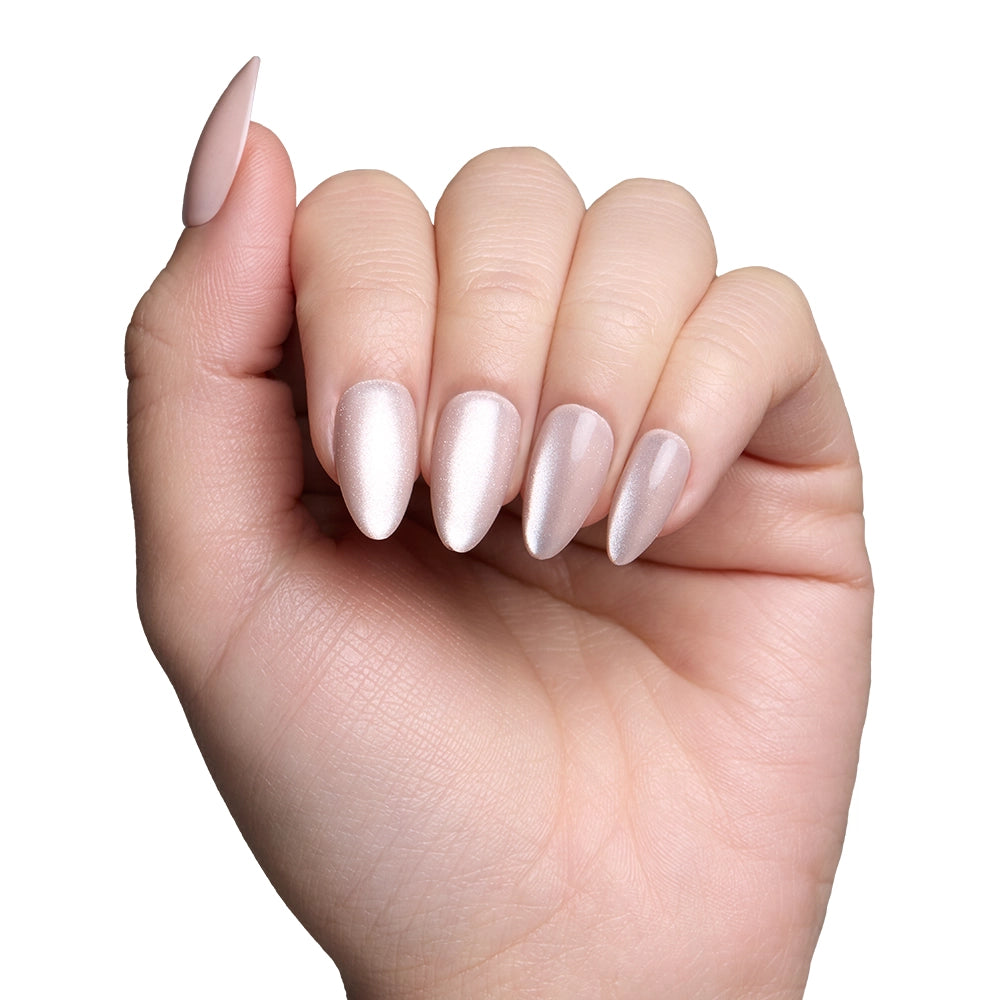 A hand with neatly manicured, almond nails coated in glamnetics The Vow—a pale, shimmery nude velvet-gloss finish—is held against a white background. - Product image
