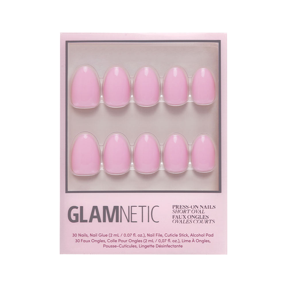 The glamnetic Think Pink set includes 10 short oval press-on nails in a soft baby pink shade, neatly arranged in two rows. Packaging displays items and product info at the bottom. - Product image