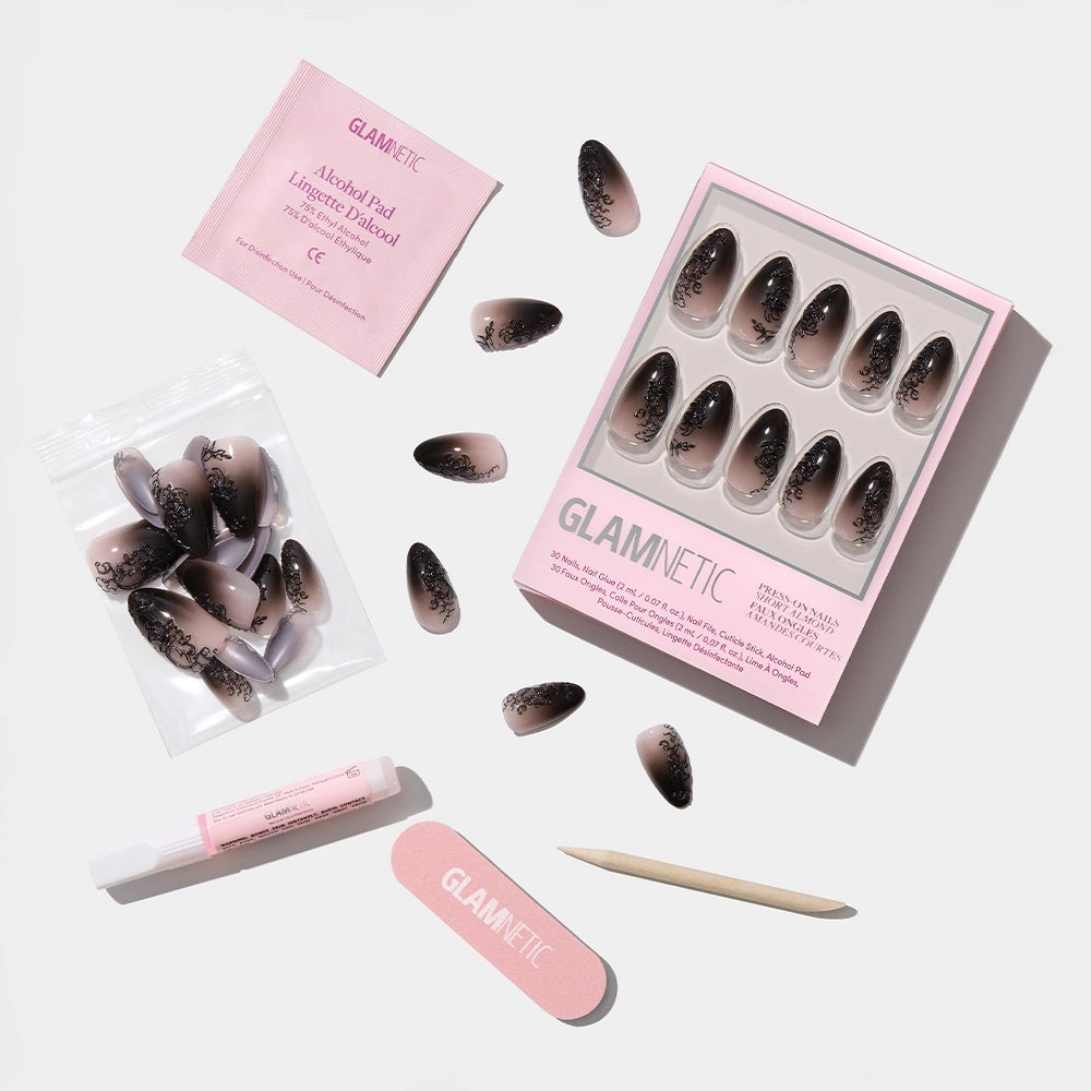 The ‘Til Death nail set by glamnetic features ombre black almond nails with a nude fade, lace accents, and includes an alcohol pad, nail glue, file, cuticle stick, and extra nails—all displayed on a white background. - Product image