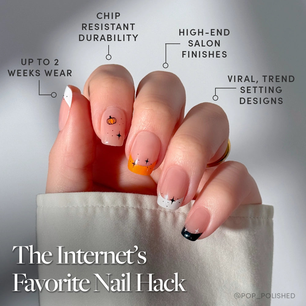A hand with almond-shaped nails wears glamnetic’s Tiny Pumpkin set in white, orange, and black with stars and a pumpkin—perfect Halloween nails. Enjoy two-week wear, chip resistance, and a salon finish. Text: The Internet’s Favorite Nail Hack. - Product image