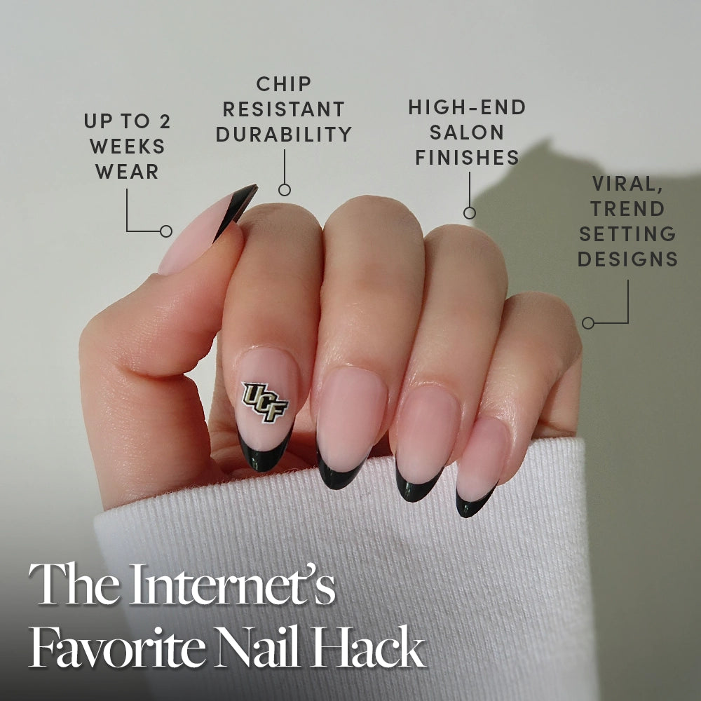 A hand shows off the glamnetic UCF Knights Press-On Nail Set with black French tips and team logo, against a neutral background. Enjoy long wear, chip resistance, salon-quality finish, and trendy designs. - Product image