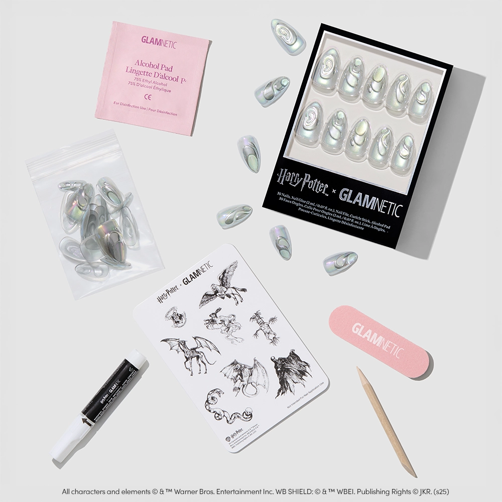 A flat lay of glamnetic's Unicorn Blood Nail Set, showing iridescent chrome nails, black nail glue, alcohol pad, nail file, magical creature tattoos, and a zip pouch. - Product image