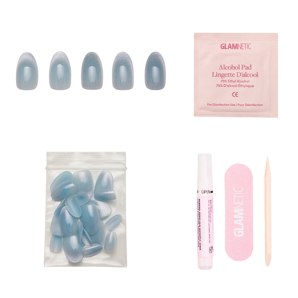Unicorn Tears by glamnetic features blue velvet metallic nails, an alcohol pad, extra nails, nail glue, a pink file, and a wooden cuticle stick arranged on a white background. - Product image