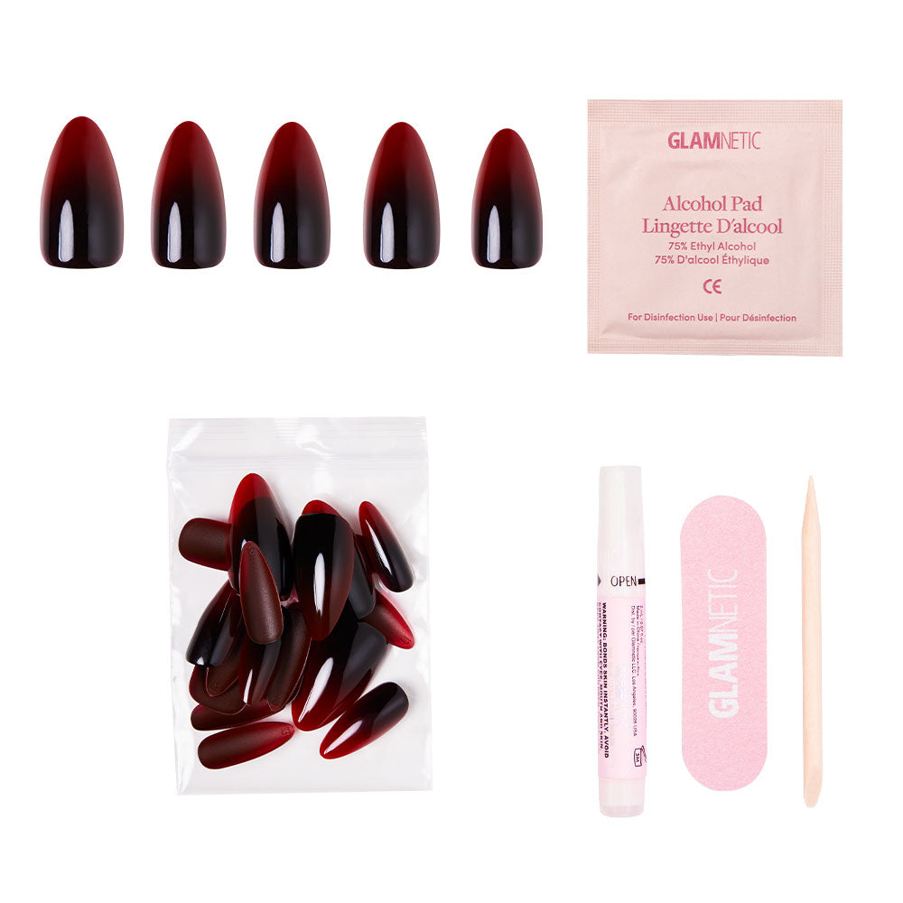 The glamnetic Vampiress press-on nail kit features burgundy and black-to-blood ombre nails, extra nails, an alcohol pad, nail glue, a pink nail file, and a wooden cuticle stick—all arranged neatly on a white background for stunning Halloween nails. - Product image