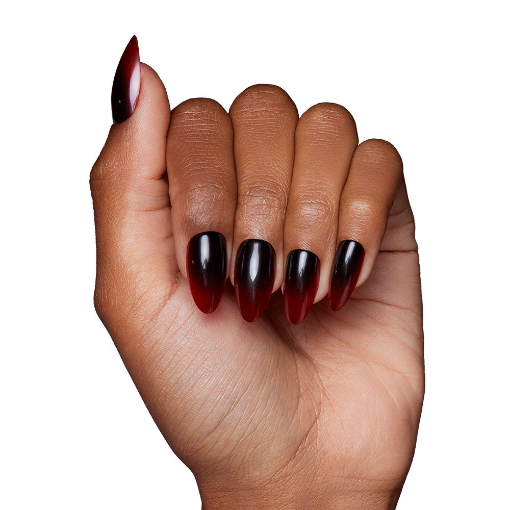 A hand with almond-shaped nails painted in a glossy black-to-blood ombre gradient, shown against a white background—perfect for showcasing the glamnetic Vampiress Nail Set and adding dramatic flair to your Halloween nails. - Product image