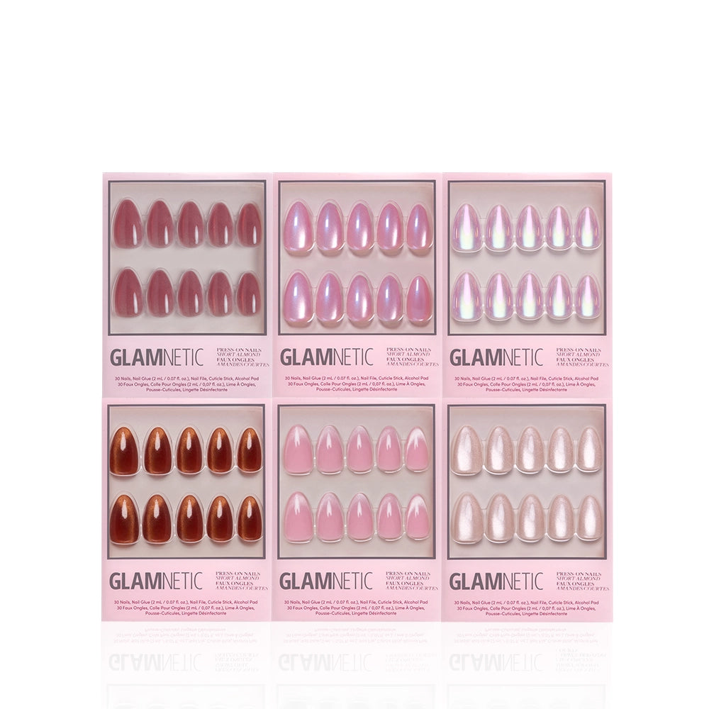 Six sets of glamnetic Velvet Vanity short almond press-on nails in pink, nude, and brown shades are displayed in pink packaging with clear windows, arranged in two rows of three on a white background for a salon-quality mani at home. - Product image