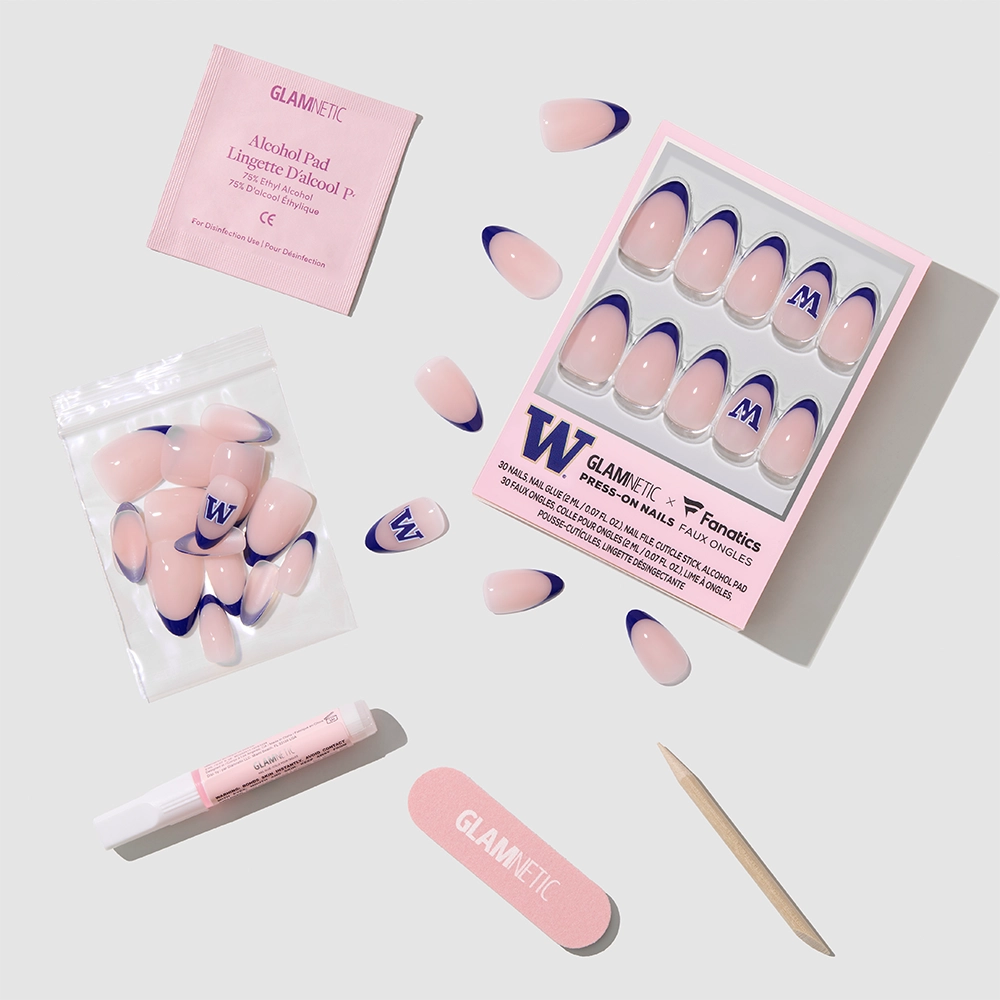 The glamnetic Washington Huskies Press-On Nail Set includes pink and navy blue nails, nail glue, a cuticle stick, pink nail file, alcohol prep pad, and extra nails—perfect for game day—and is neatly arranged on a light gray background. - Product image