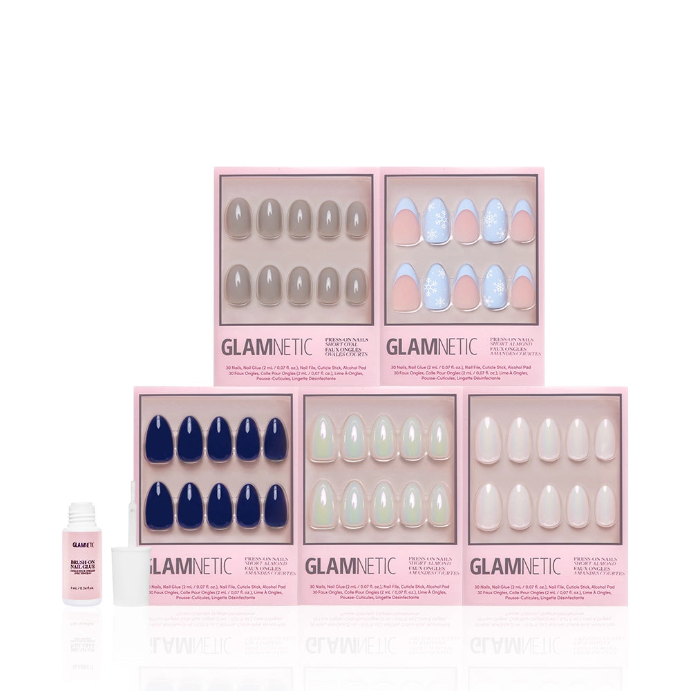 Five boxes of the glamnetic Winter Toast Bundle, featuring cool-toned and holographic chrome press-on nails in various finishes, are arranged in two rows with a small nail glue bottle placed to the left front of the boxes. - Product image
