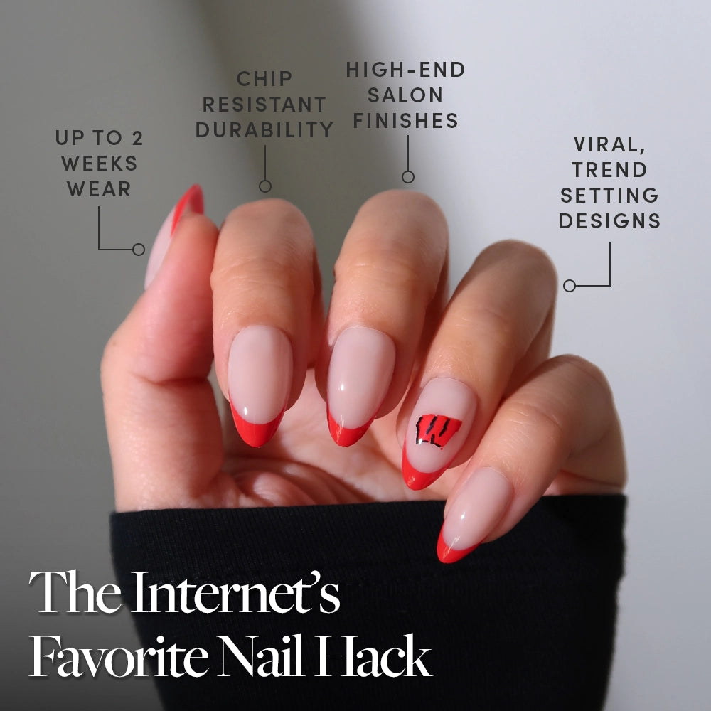 A hand with a red French manicure and W accent nail shows the glamnetic Wisconsin Badgers Press-On Nail Set, featuring up to 2 weeks’ wear, chip-resistant durability, salon-quality finishes, and trendsetting designs: The Internet’s Favorite Nail Hack. - Product image
