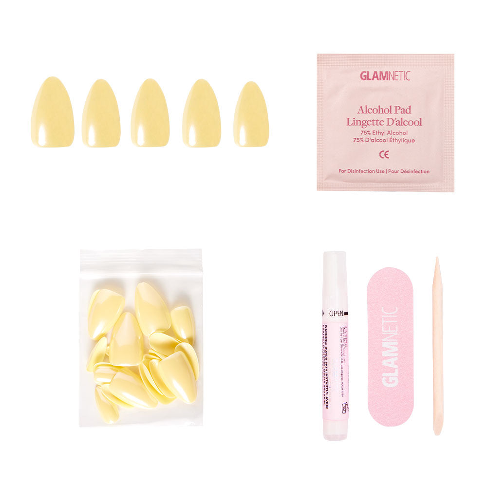 The glamnetic Yellow Pop nail set includes pastel yellow press-ons, an alcohol pad, extra nails, nail glue, a pink file, and a wooden cuticle stick, all displayed on a white background. - Product image