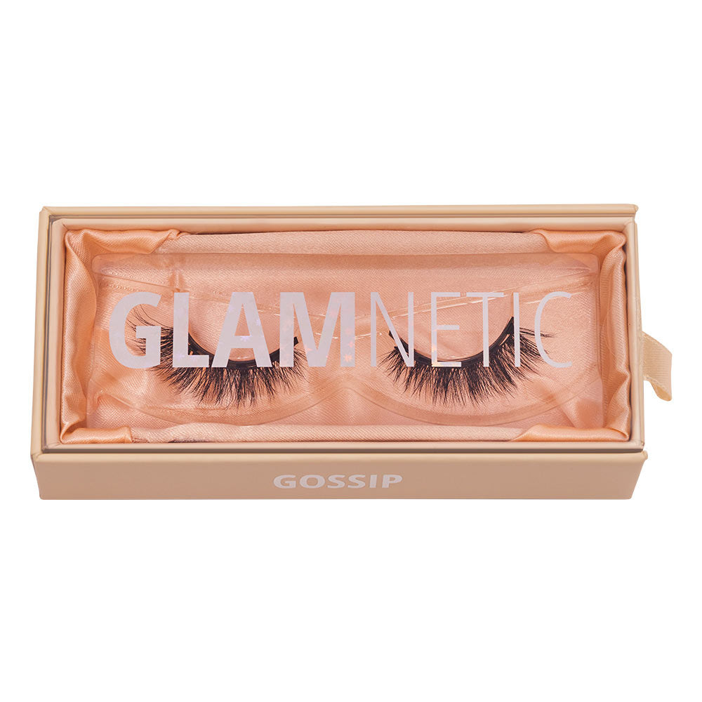 A pair of glamnetic Gossip lashes made from Japanese synthetic fiber come in a peach-colored box with PowerGrip Magnets and rest on a soft satin liner. - Product image