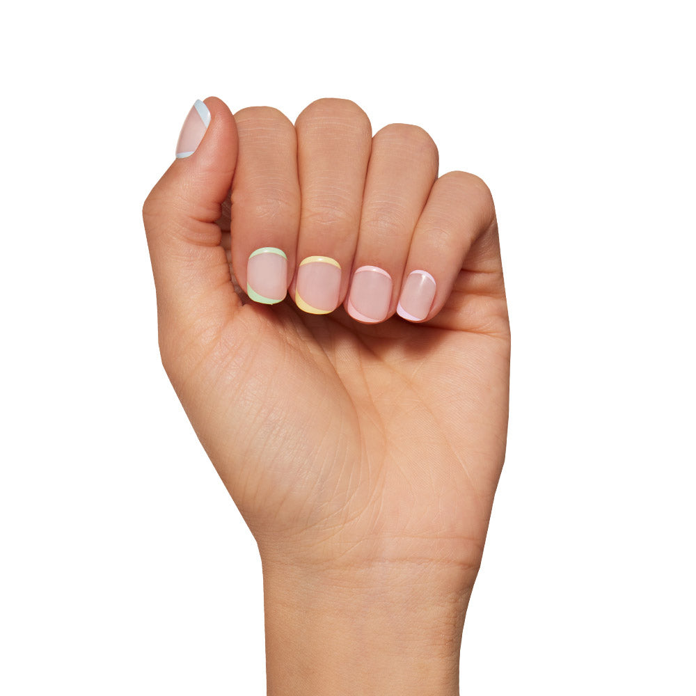 A hand with light skin tone flaunts super short, neatly manicured nails featuring glamnetics Tutti Frutti—a minimalist pastel-tipped design on a natural base. Perfect for fans of vegan & cruelty-free nail care, shown against a white background. - Product image