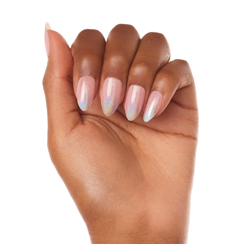 A hand with medium brown skin displays almond-shaped nails painted with glamnetics Winter Storm, a shiny, iridescent pale pink polish. The semi-transparent finish stands out against a white background, highlighting the nails. - Product image