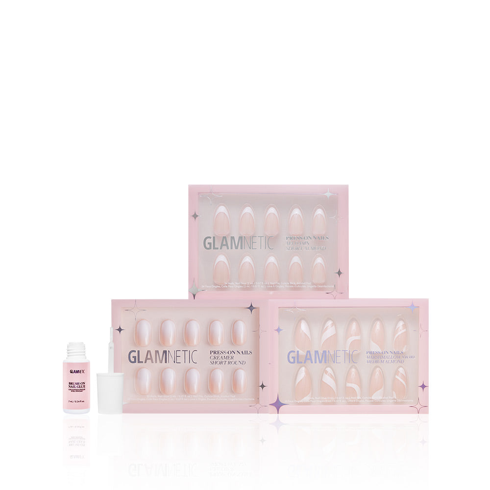 Three boxes of glamnetic Timeless Tips press-on nails are stacked in a pyramid. To the left, an open glamnetic Nail Glue with its white cap sits beside them, all on a white background. - Product image
