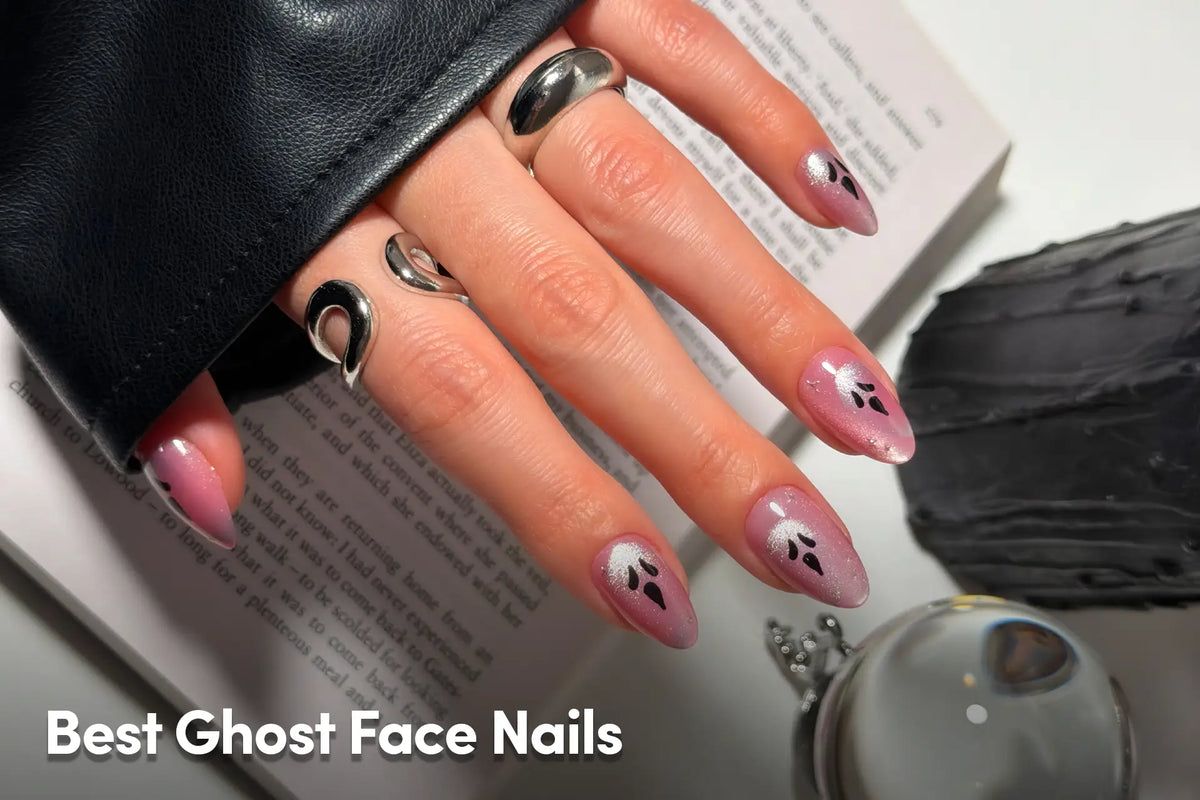 Pink almond nails with ghost face designs and chrome accents.