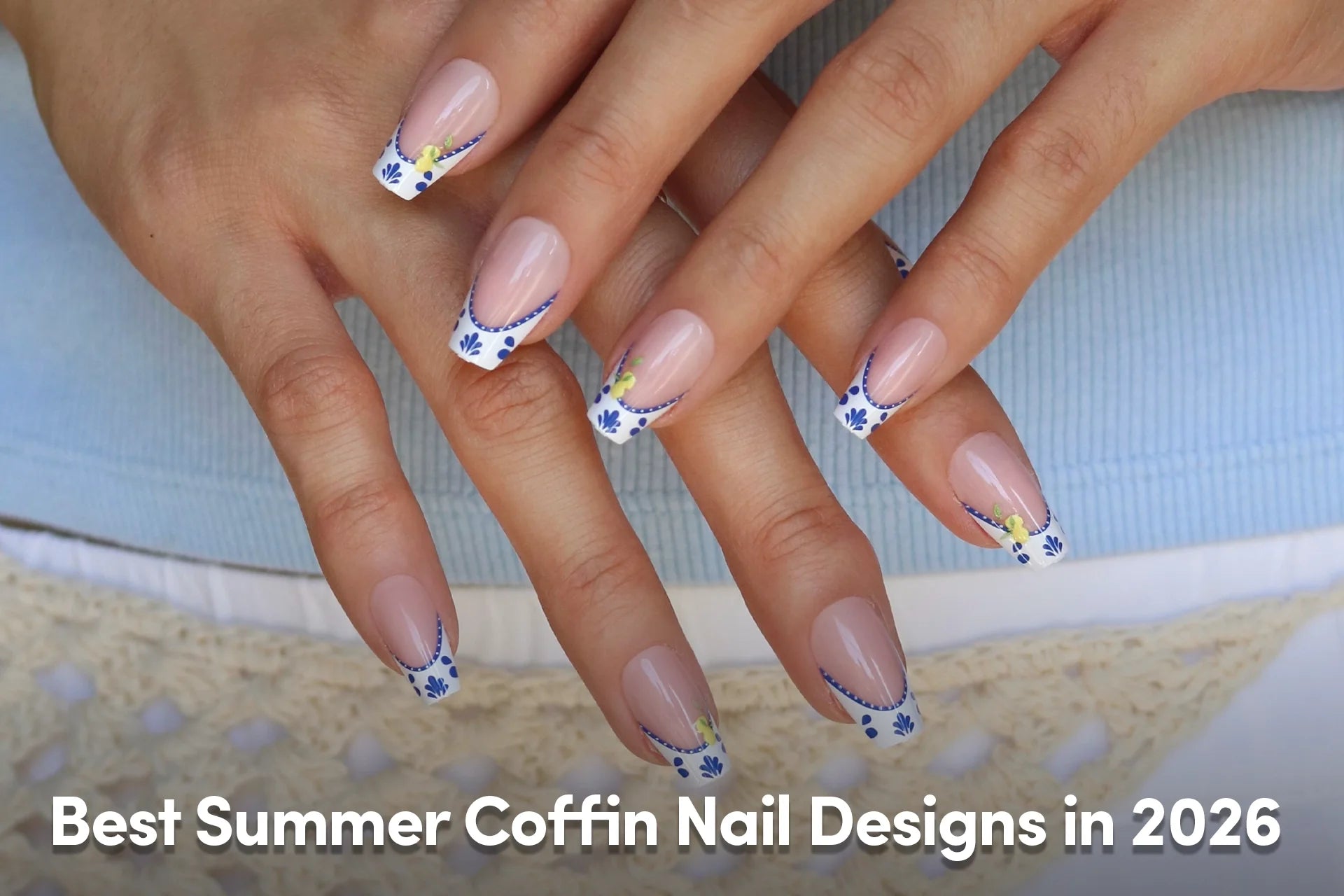 Nude coffin nails with blue French tips and delicate lemon-floral details.