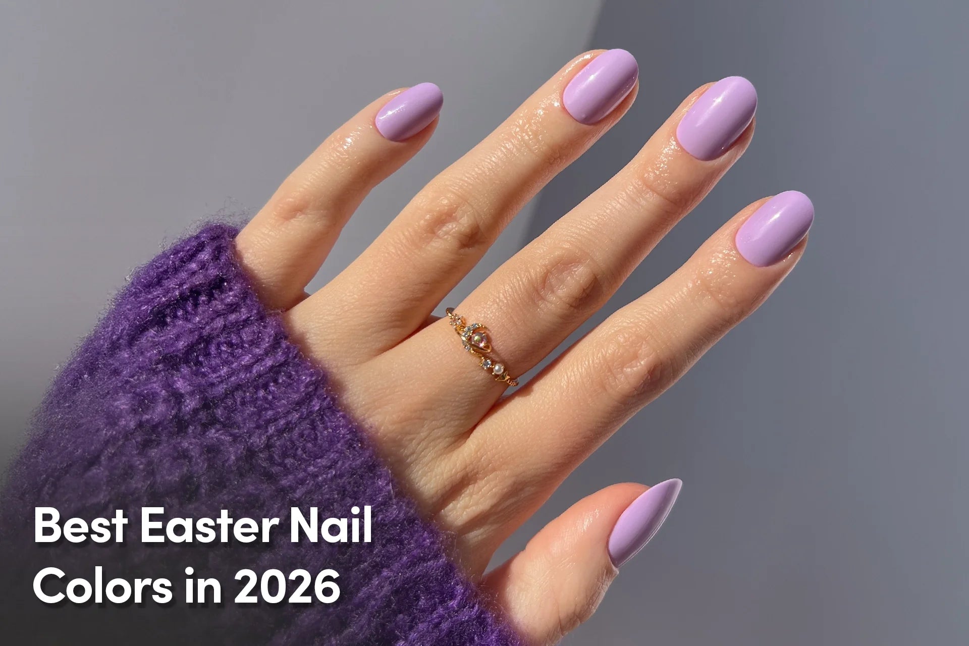 Hand with glossy pastel lavender nails and gold ring, showcasing Easter nail color trends.