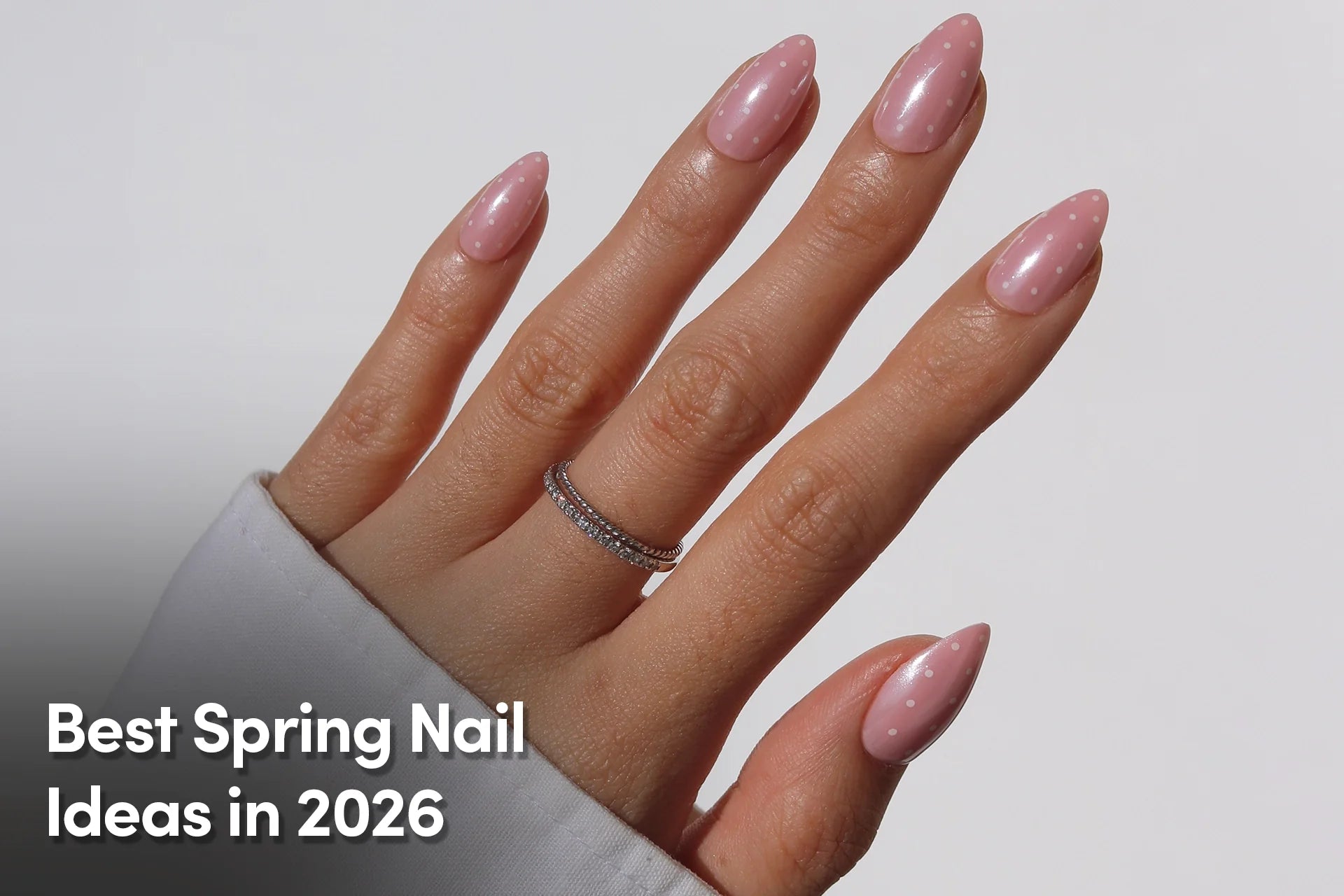 Soft pink almond nails with white polka dot design