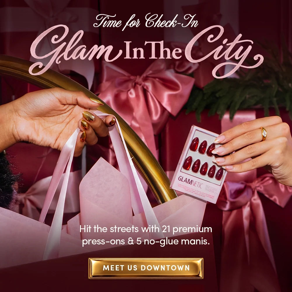 Promotional image for Glamnetic press-on nails featuring a hand holding a pack of dark red nails, with text reading Time for Check-In Glam In The City and Hit the streets with 21 premium press-ons & 5 no-glue manis.
