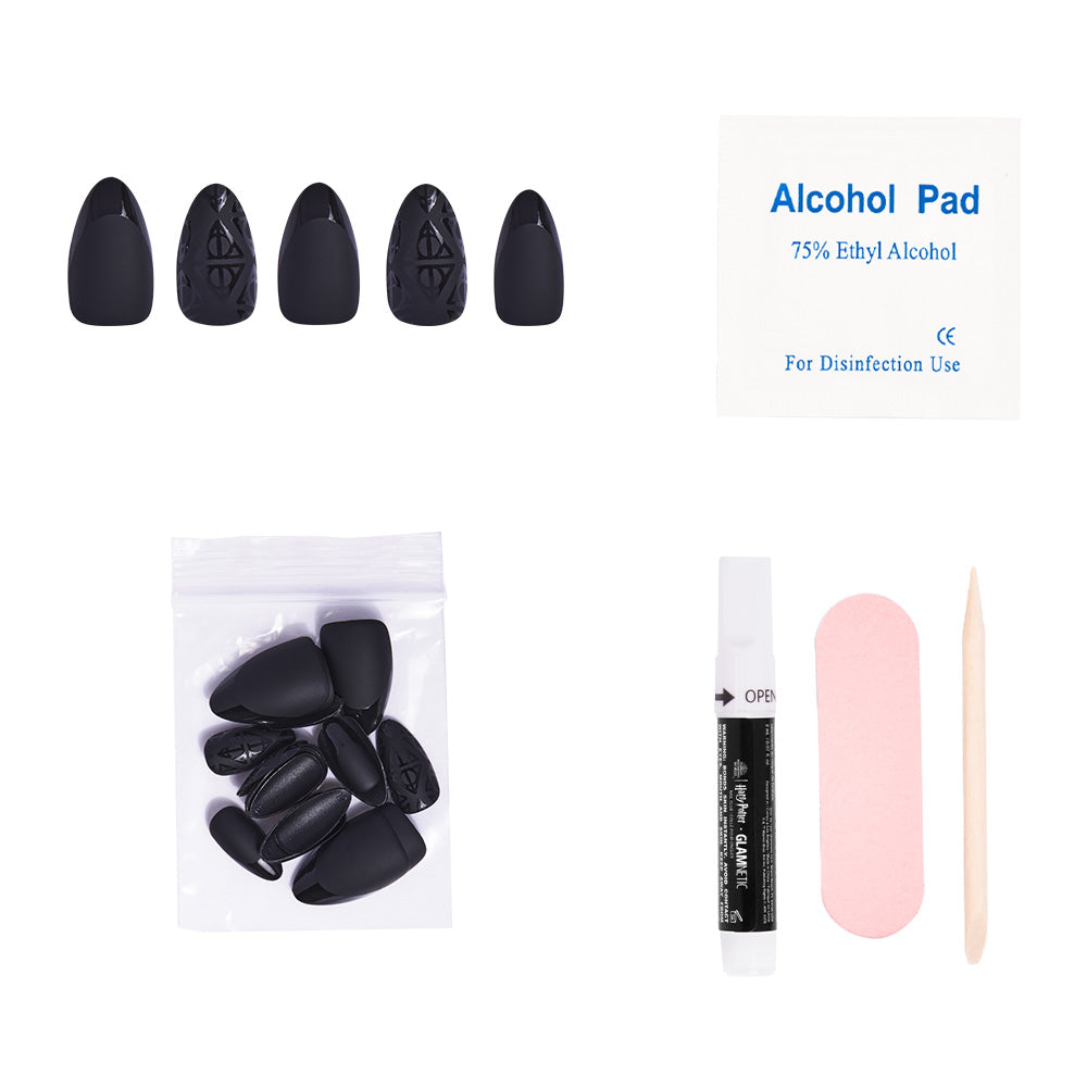 The glamnetic Deathly Hallows™ press-on nail set includes black nails, an alcohol pad, extra nails in a bag, nail glue, a pink file, and a wooden cuticle stick—all neatly arranged on a white background. - Product image
