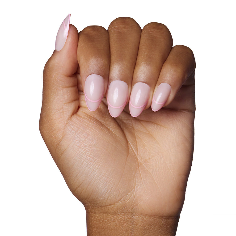 A hand with medium brown skin displays short, almond-shaped nails painted with glamnetics Hot Take—a pale pink polish with a glossy finish. The well-manicured nails are shown against a white background, highlighting the elegant look. - Product image