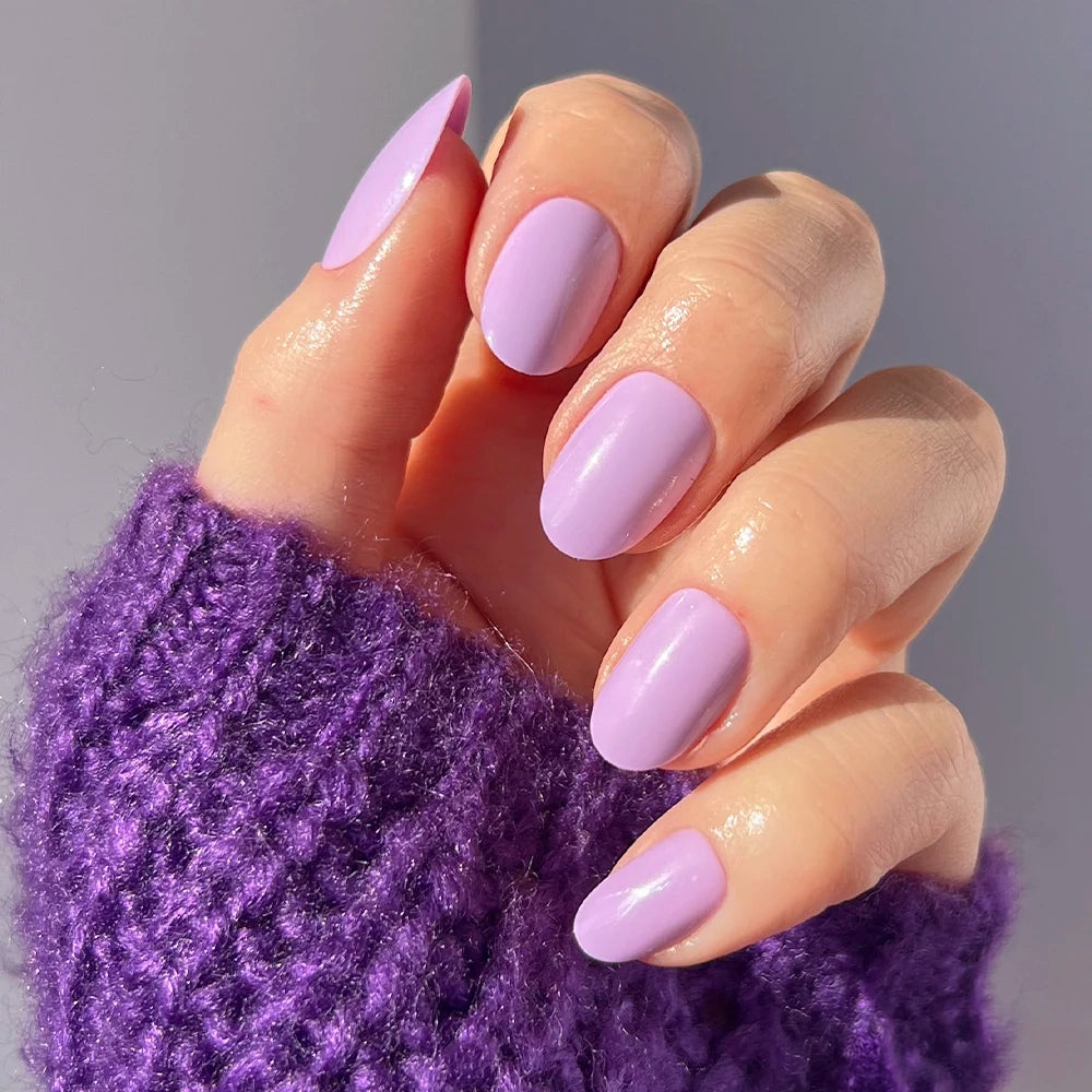 A hand wearing Glamnetic Lilac press-on nails with an almond shape and glossy finish.