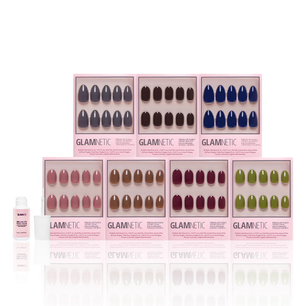Seven boxes of glamnetic’s The Solids Vol.3 Fall Forest Collection vegan press-on nails in fall colors are shown with a bottle of nail glue on a white background. - Product image