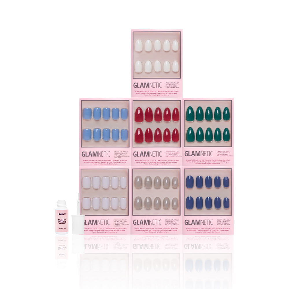 A pyramid of seven Glamnetic Winter Opulence press-on nail sets in white, red, blue, teal, and gray with nail glue—perfect for easy at-home manicures—displayed on a white background. - Product image