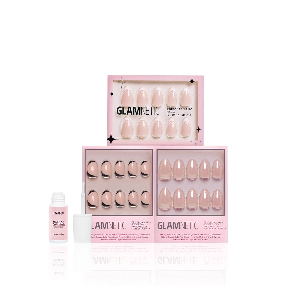 Three pink boxes of glamnetic Glam and the City salon-quality press-ons with nude designs and a small white nail glue bottle are displayed against a white background, presenting an elegant manicure nail set bundle. - Product image