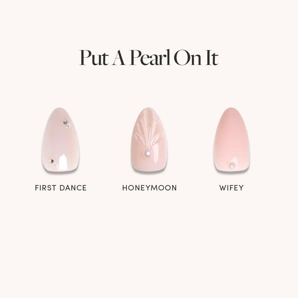 Three almond manicure designs in light pink by glamnetic: First Dance with 3D pearl accents and a gem, Honeymoon with a pearl and white lines, and Wifey with a single pearl. Perfect bridal press-on nails. Text reads Put A Pearl On It.