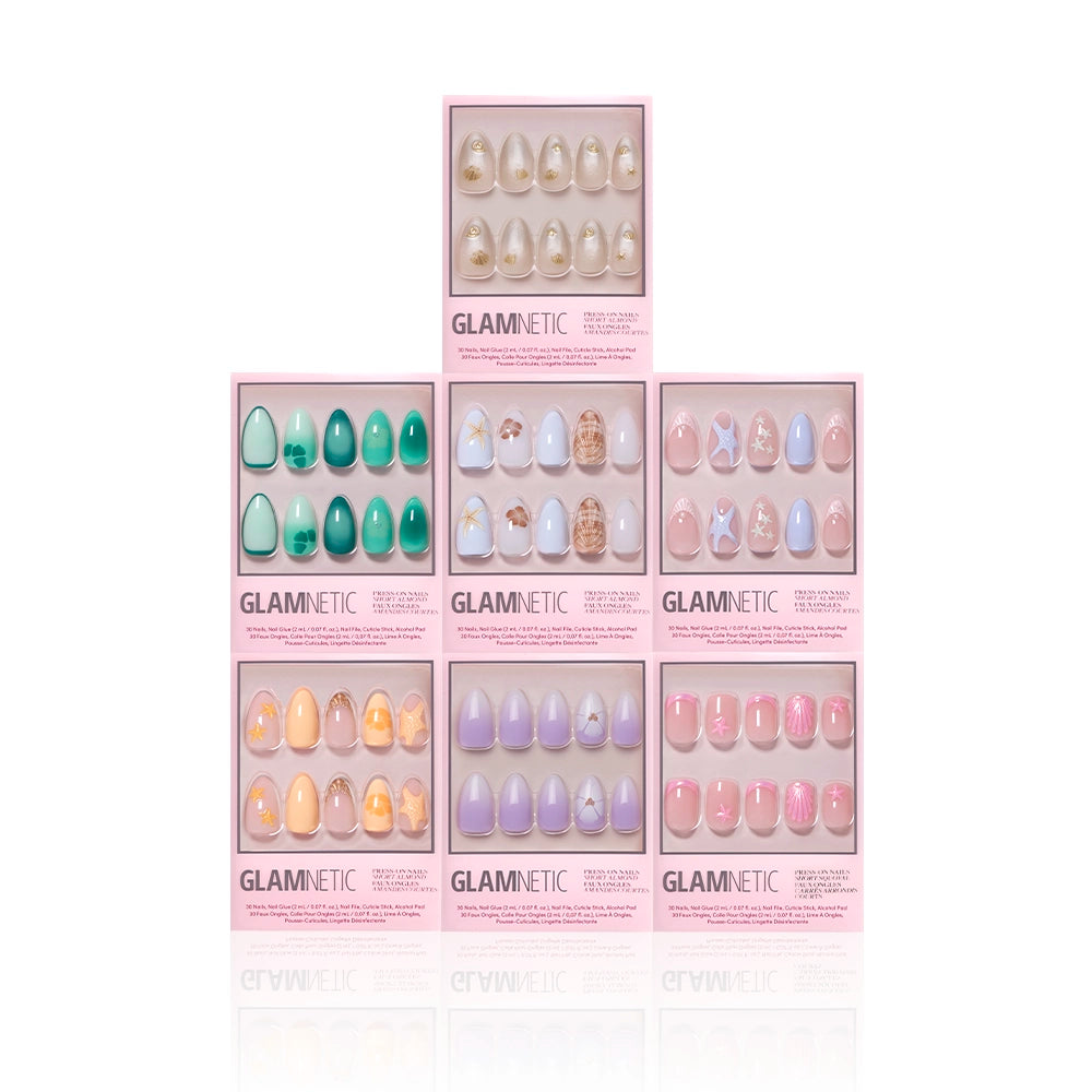 Seven boxes of glamnetic press-on nails, featuring the Mermaid Jewels set, are arranged in a pyramid shape against a white background, each showcasing its unique nail designs through a clear window. - Product image