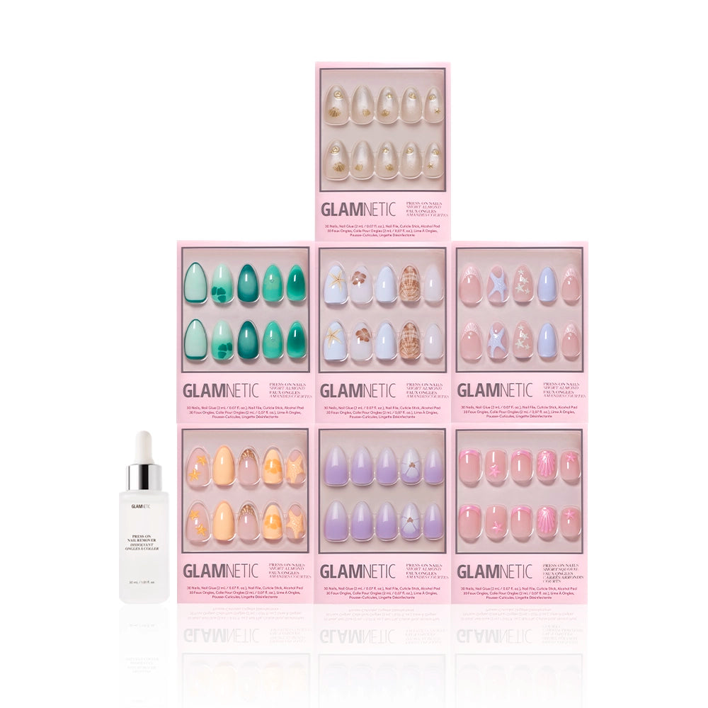 Seven boxes of glamnetic Mermaid Jewels press-on nails are stacked in a pyramid formation, with a white dropper bottle of serum placed in front, all shown against a white background. - Product image