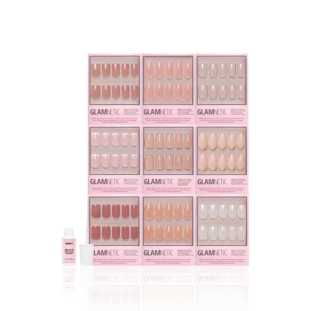 Nine boxes of glamnetic’s Timeless Tones Collection press-on nails in elevated neutrals are displayed in a grid, with a small pink nail glue bottle placed in front on a white background. - Product image
