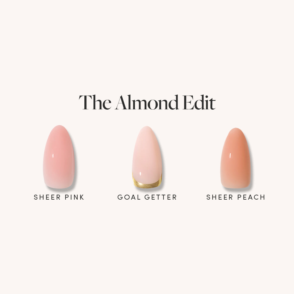 The Almond Edit by glamnetic displays three medium almond nails in sheer glossy neutrals—sheer pink, Goal Getter (sheer pink with gold tip), and sheer peach—on a light background, embodying feminine elegance.