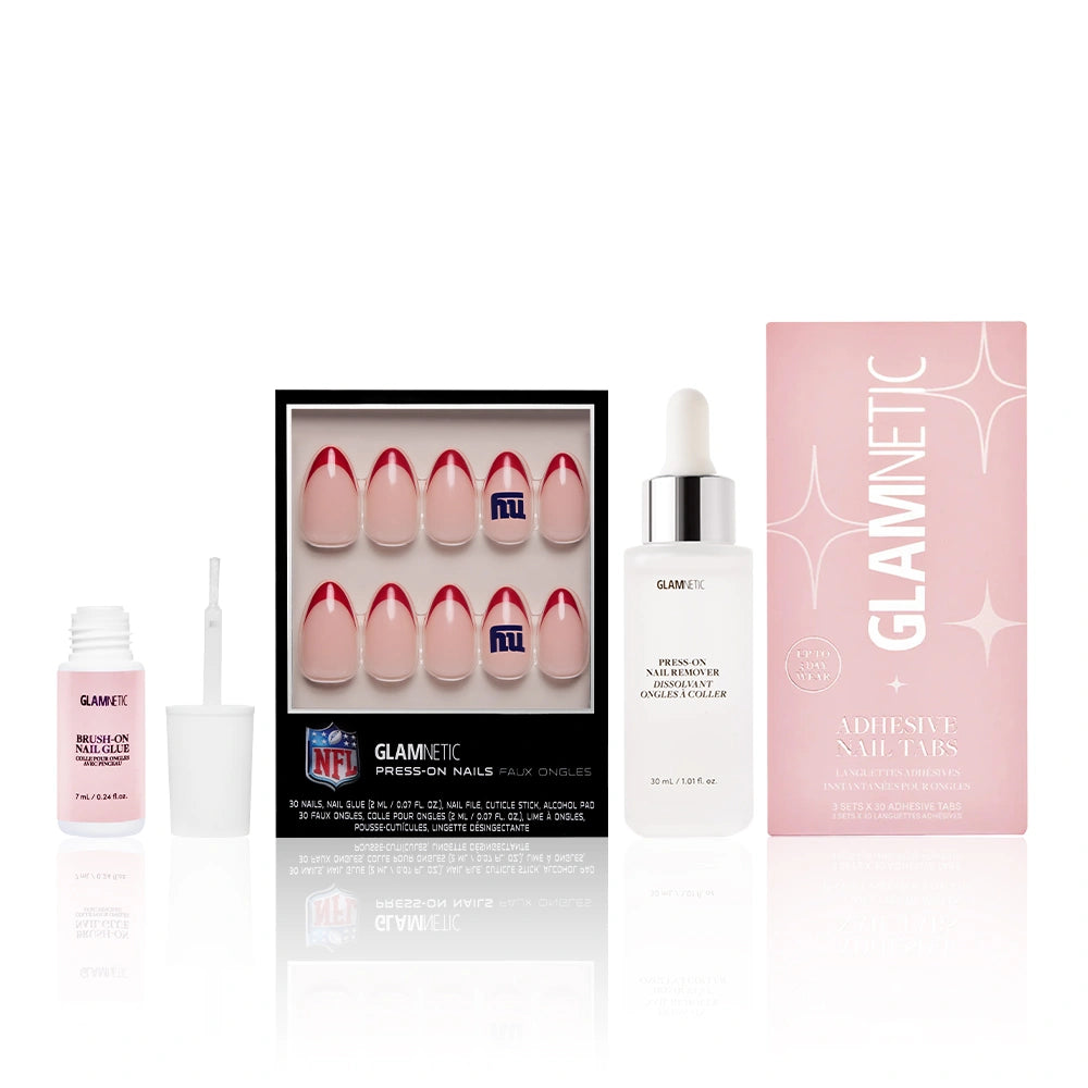 The glamnetic New York Giants Press-On Playbook is a salon-quality nail set with red French tip press-ons featuring the NFL logo, shown with nail glue, adhesive tabs, and a glossy nail bottle on a white background.