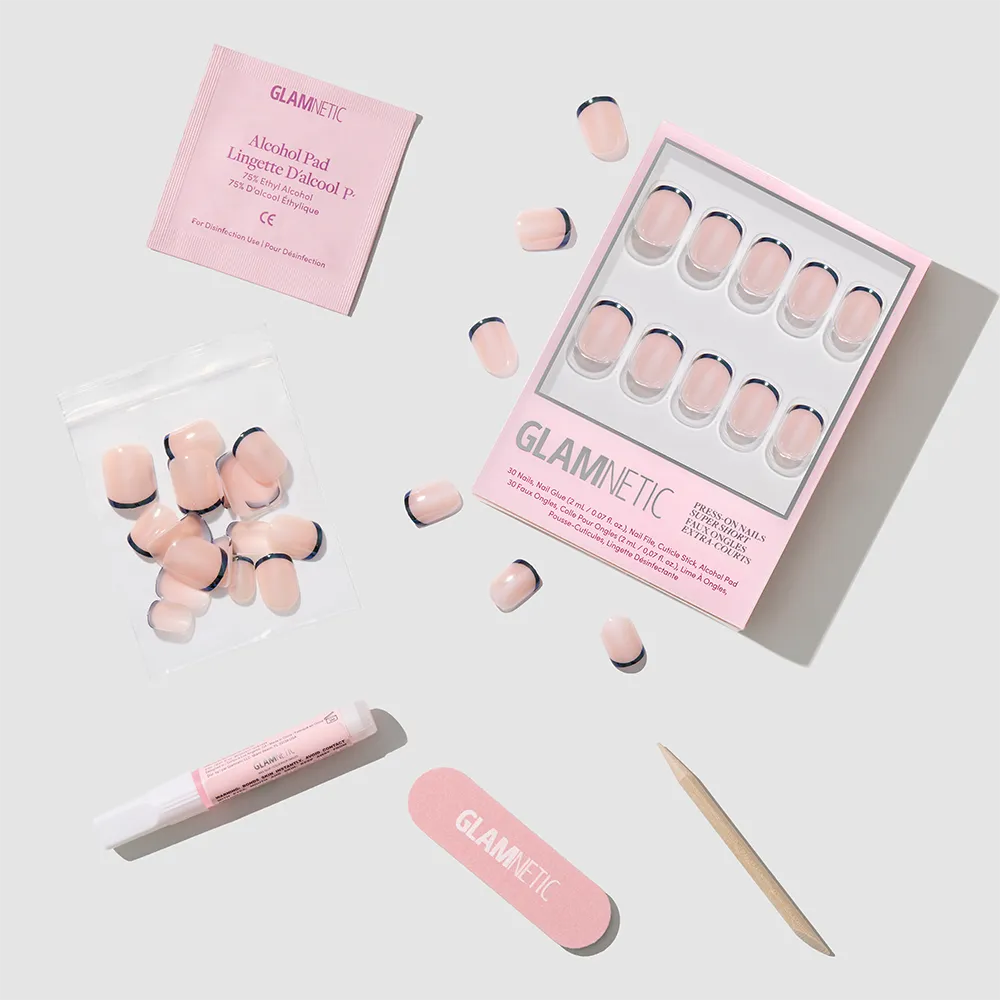 Flat lay of the glamnetic Burnt Miso Press-On Nails kit, showing pink and black French tips with a glossy finish, plus glue tube, nail file, cuticle stick, alcohol pad, and extra nails on a light gray background. - Product image